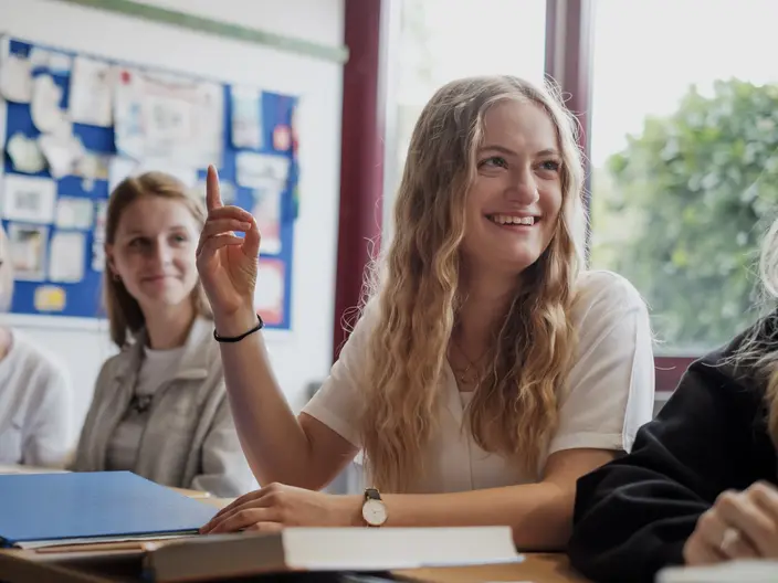 Schülerin meldet sich und lächelt.
